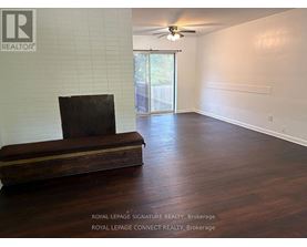 A room with a wooden floor and a brown couch.