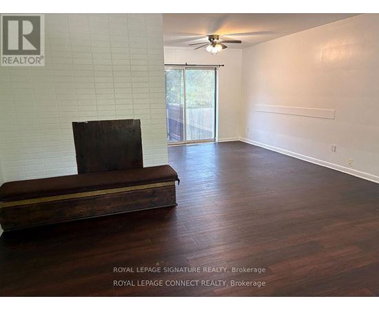 A room with a wooden floor and a brown couch.