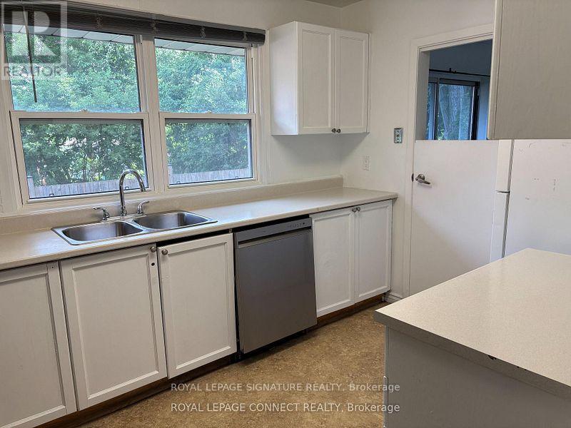 A kitchen with white cabinets and a window.