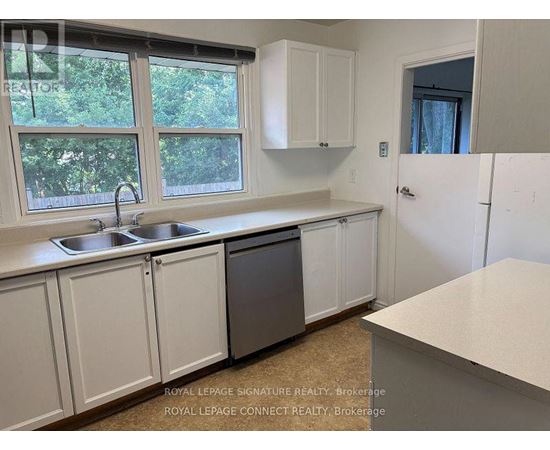 A kitchen with white cabinets and a window.