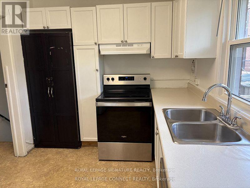 A kitchen with a black fridge, stove, and dishwasher.