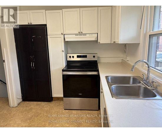 A kitchen with a black fridge, stove, and dishwasher.