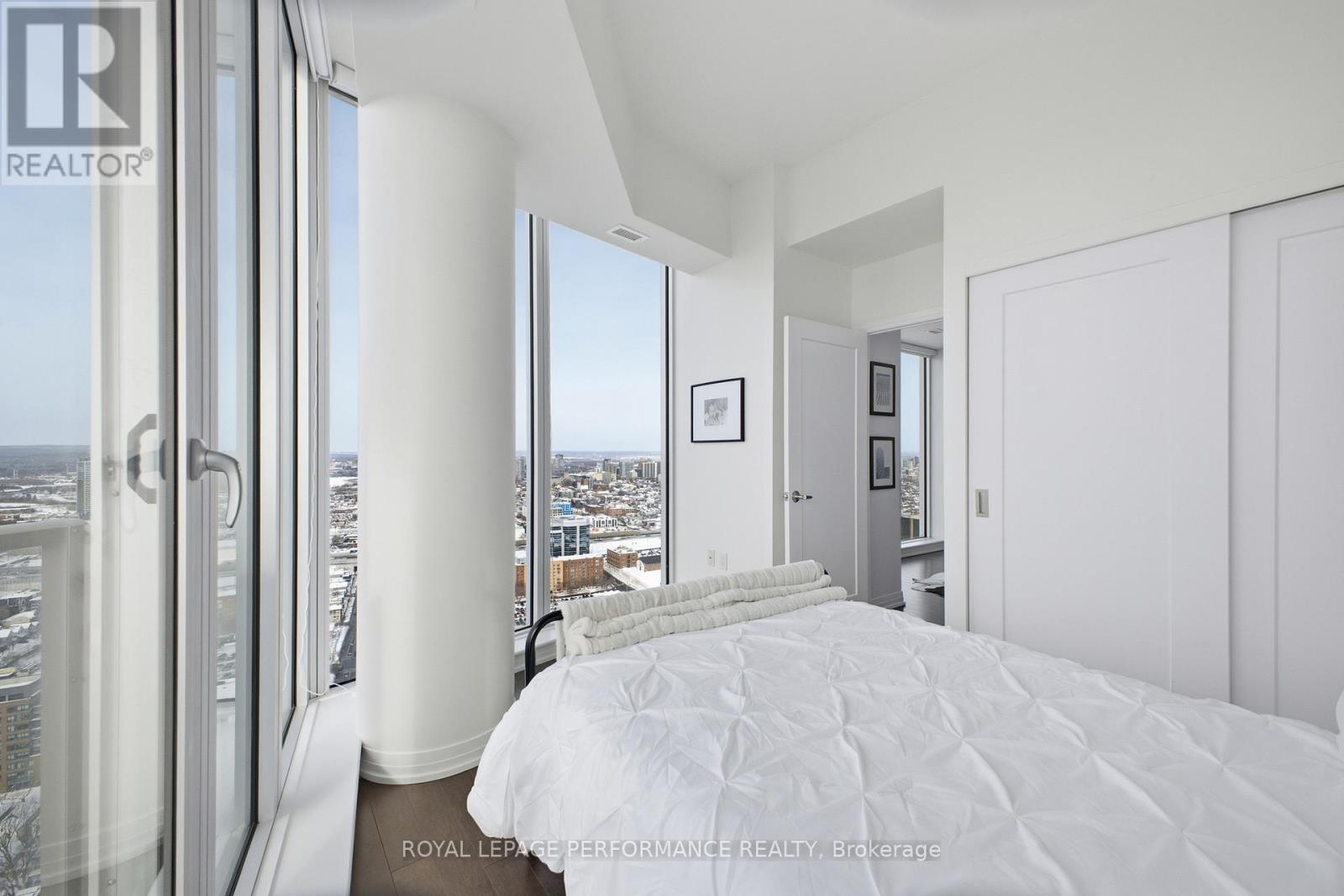 A bedroom with a large bed and a view of the city.