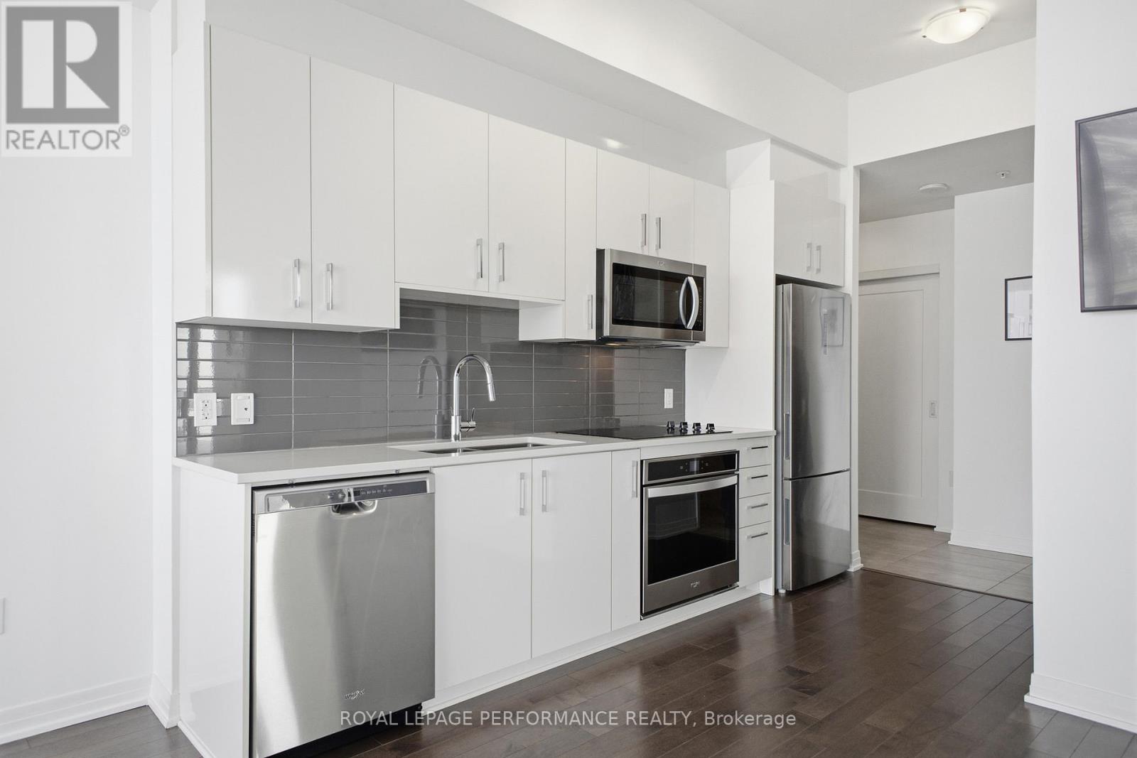 A kitchen with white cabinets and stainless steel appliances.