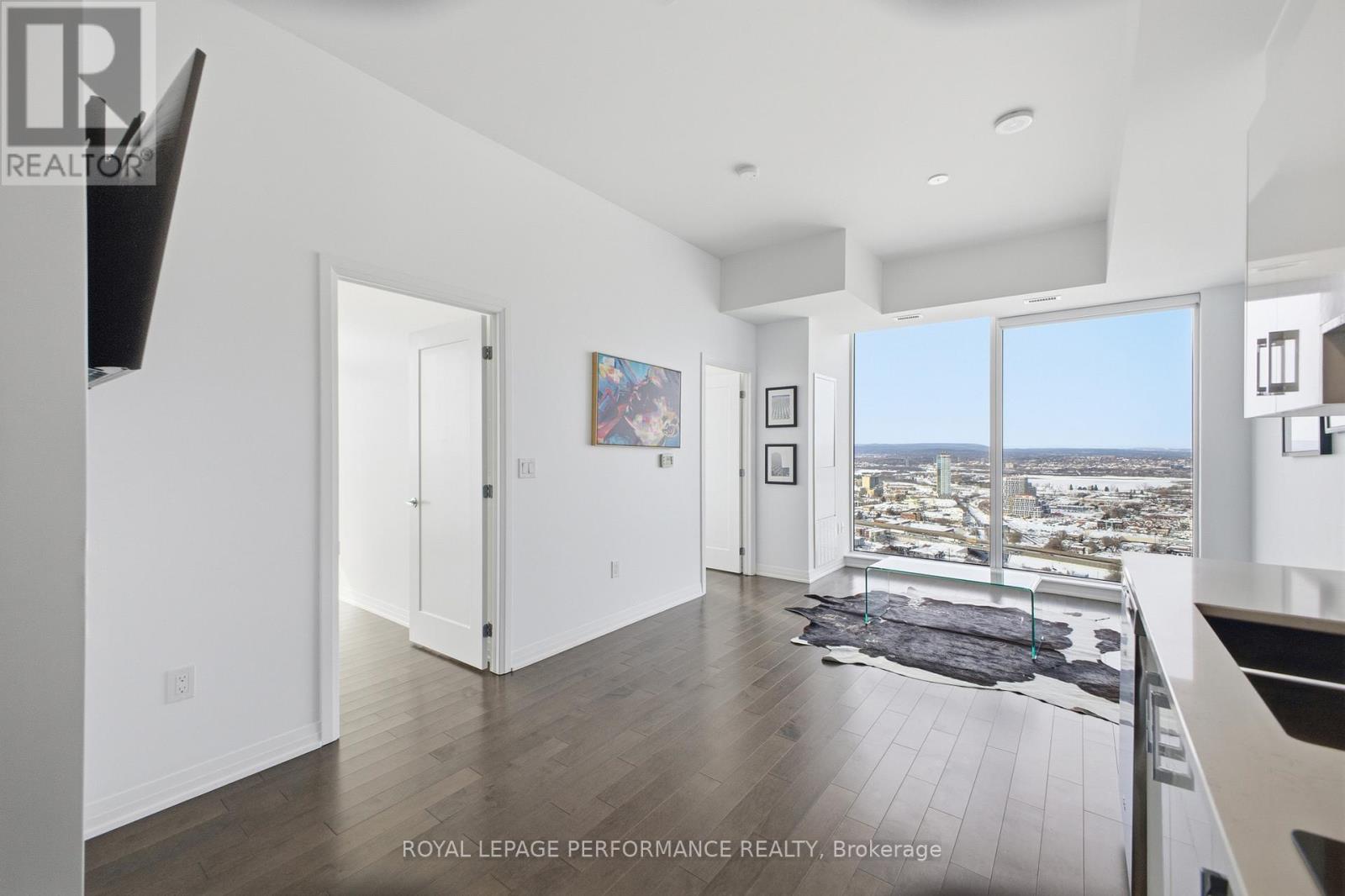 A spacious room with a view of the cityscape through the windows.