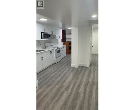 A kitchen with white cabinets and a microwave above the stove.