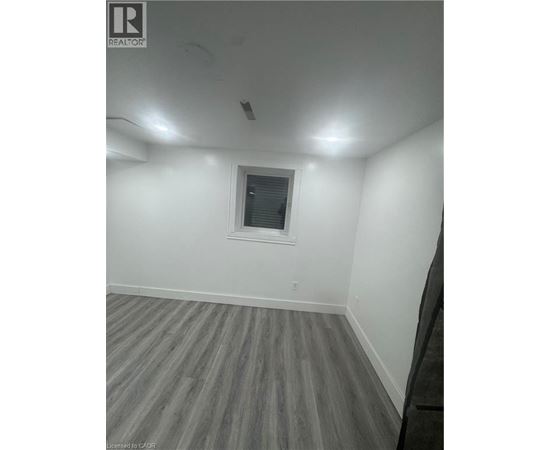 A room with a window and wooden flooring.