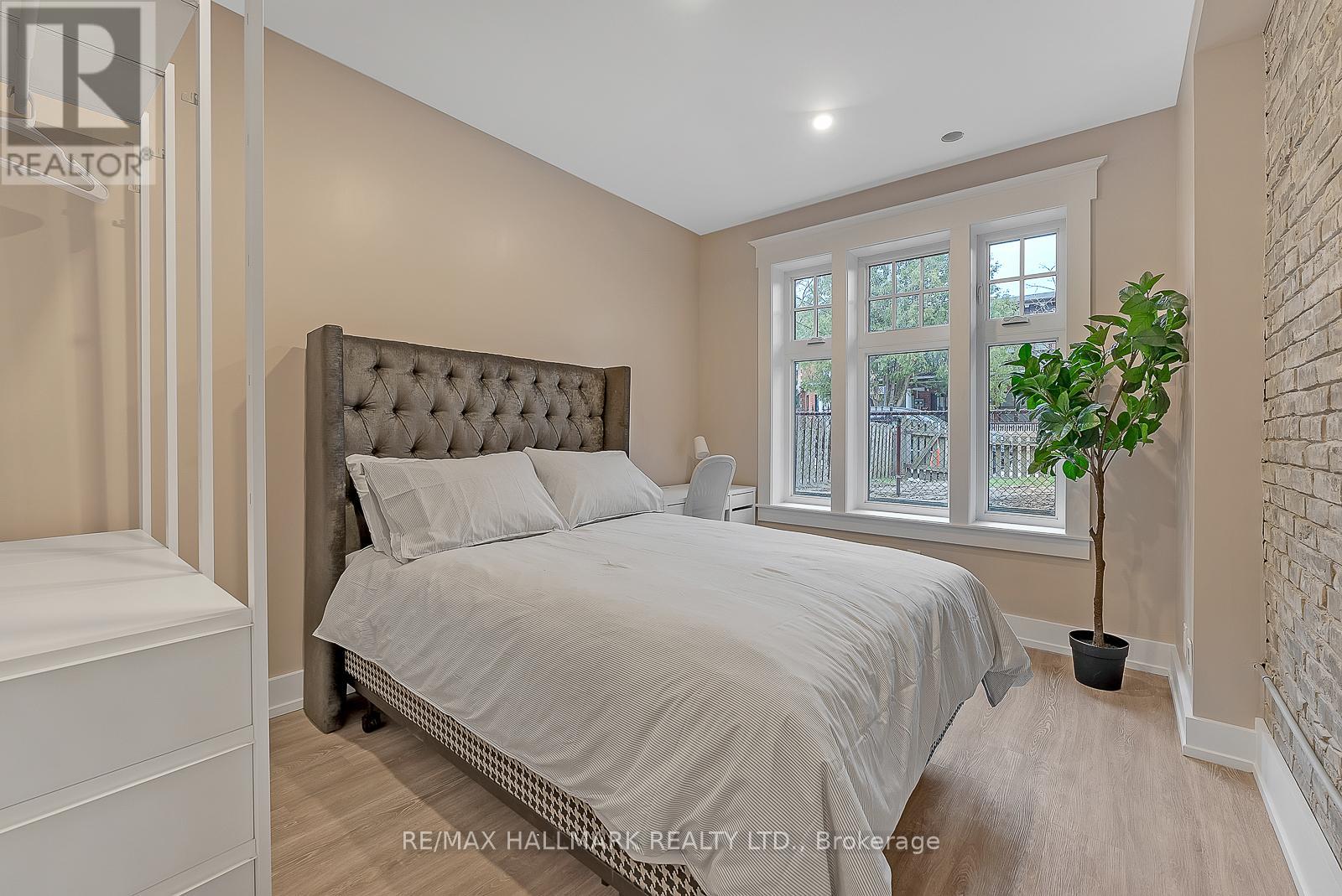 A bedroom with a large bed and a potted plant.