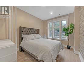 A bedroom with a large bed and a potted plant.