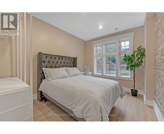 A bedroom with a large bed and a potted plant.