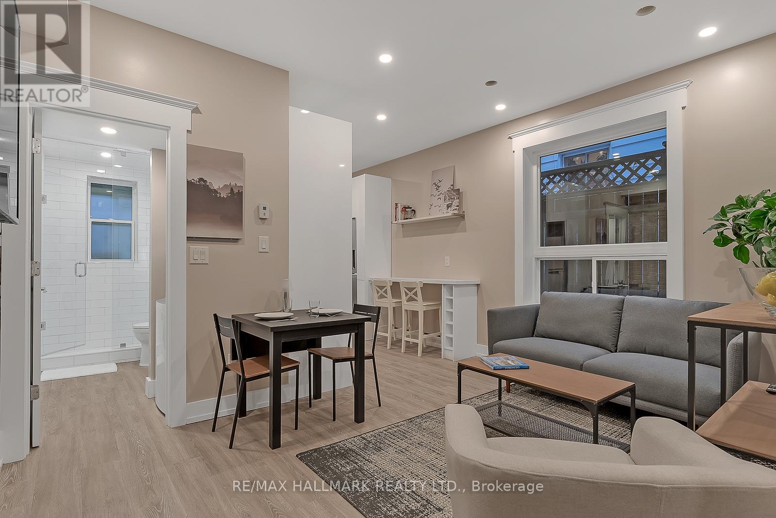 A well-lit living room with a dining table and grey sofa.