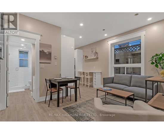 A well-lit living room with a dining table and grey sofa.