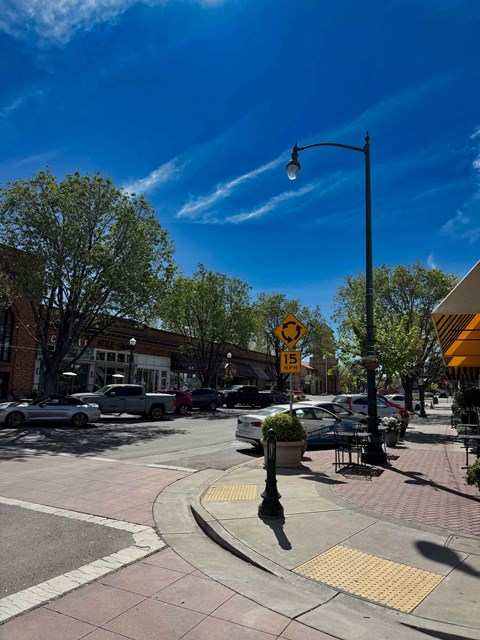 A street view with a pedestrian crossing and a yellow warning sign.