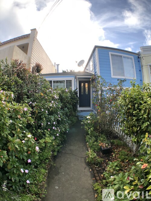 A blue house with a garden in front.