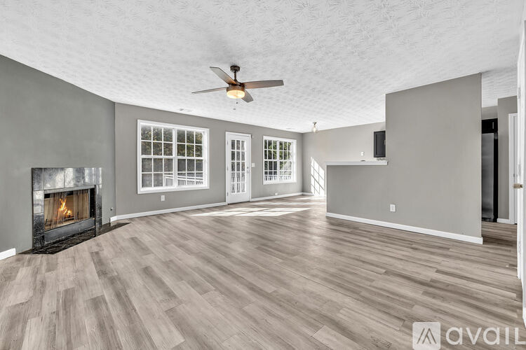 A spacious living room with a fireplace and hardwood floors.
