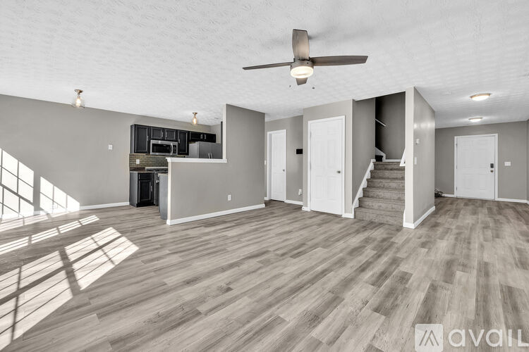 A spacious room with a ceiling fan and lighting fixtures.