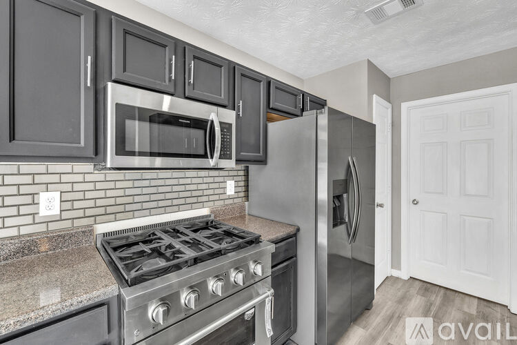 A kitchen with a stove, microwave, and refrigerator.