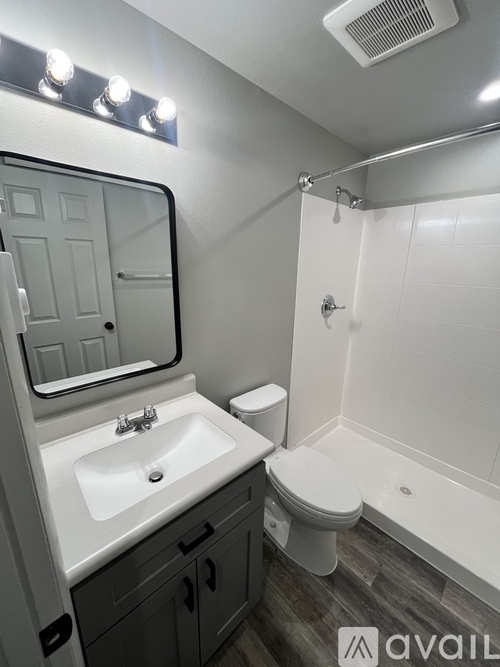 A bathroom with a sink, mirror, toilet and tub.