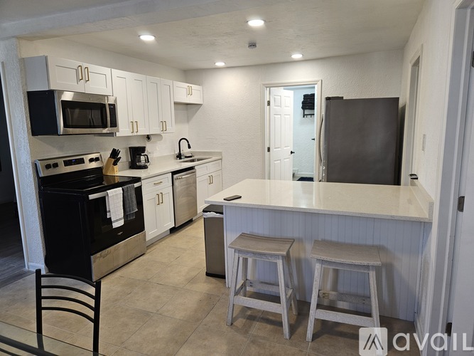 A kitchen with black appliances and white cabinets.