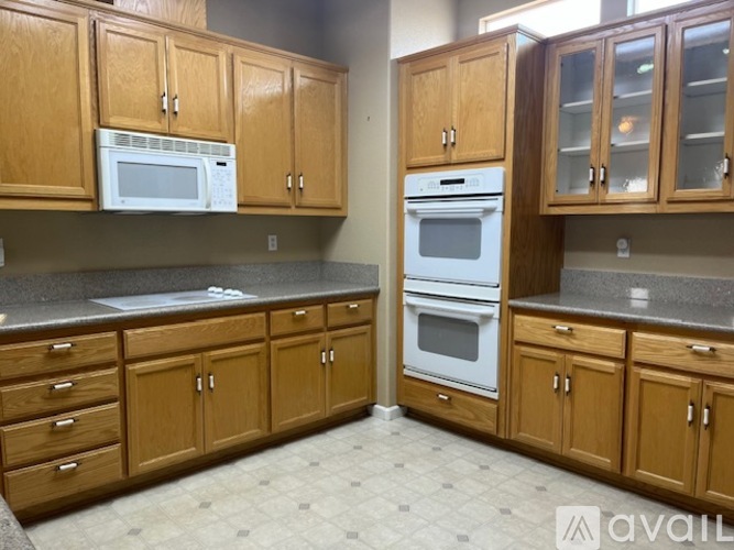 A kitchen with wooden cabinets and a white microwave.