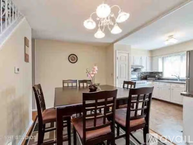 A dining room with a table and chairs.