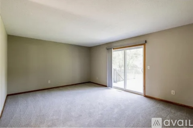 A room with a carpeted floor and a sliding glass door.