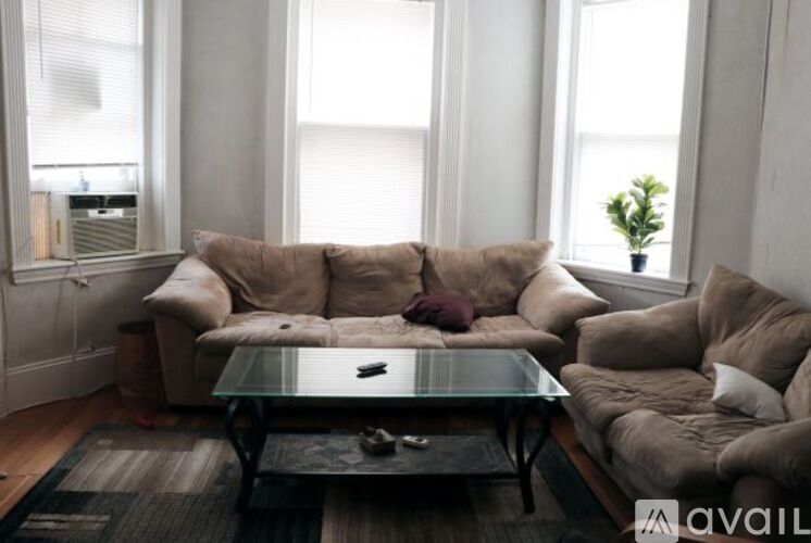 A living room with a glass coffee table and a large sectional sofa.