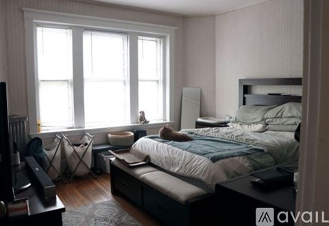 A bedroom with a bed, a dresser, and a window.