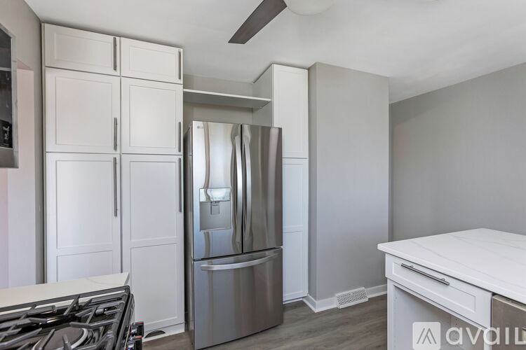 A modern kitchen with a stainless steel refrigerator and a white countertop.