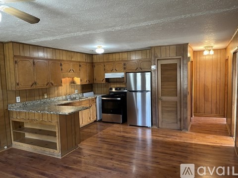 A kitchen with wooden cabinets and a granite countertop.