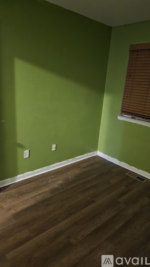 A room with green walls and wooden flooring.