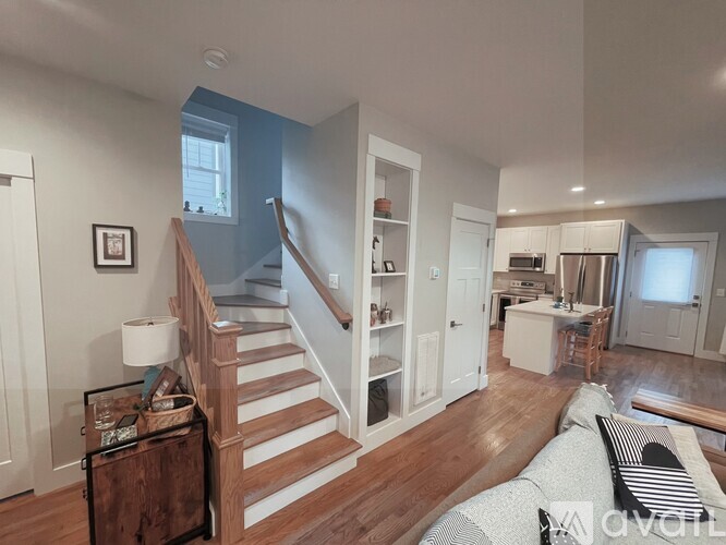 A living room with a couch and a staircase.
