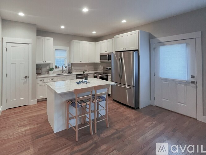 A kitchen with white cabinets and a wooden island.
