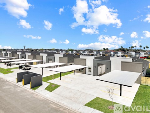 A parking lot with a few cars and a building in the background.