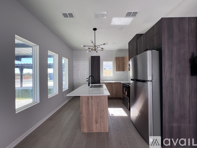 A modern kitchen with a large island and stainless steel appliances.