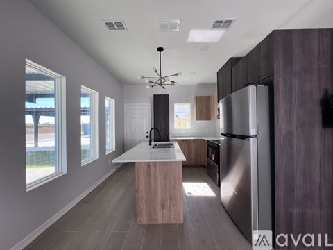 A modern kitchen with a large island and stainless steel appliances.