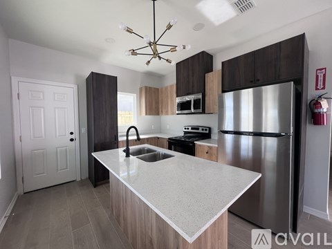 A modern kitchen with a stainless steel refrigerator and a white countertop.