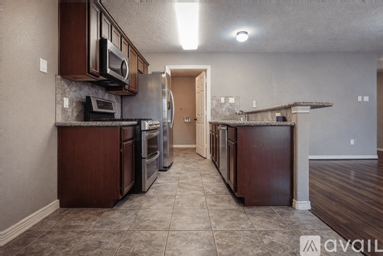A kitchen with brown cabinets and a tile floor.
