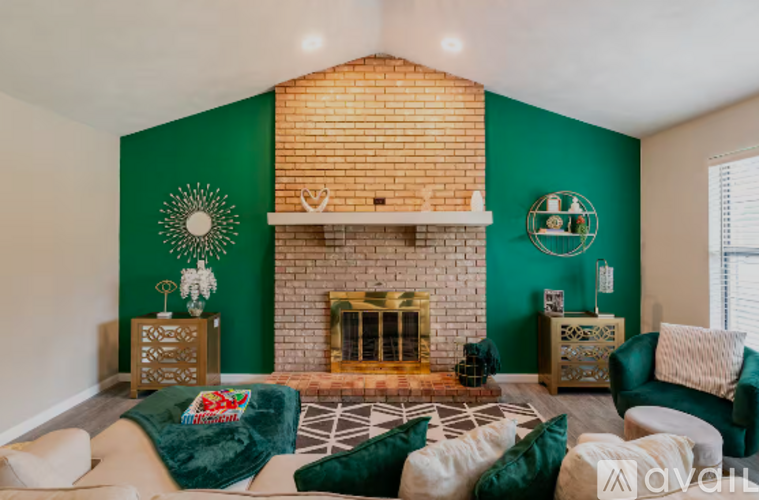 A living room with a fireplace and a green couch.