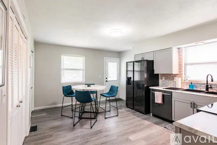 A kitchen with a table and chairs in the middle of the room.