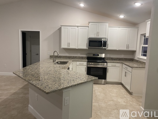 A kitchen with granite countertops and white cabinets.