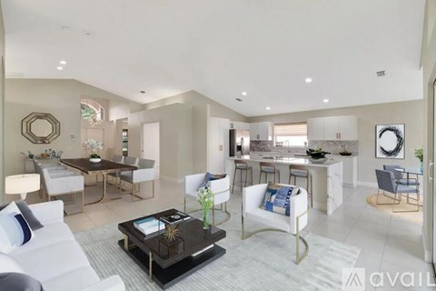 A modern living room with a white sofa set and a black coffee table.