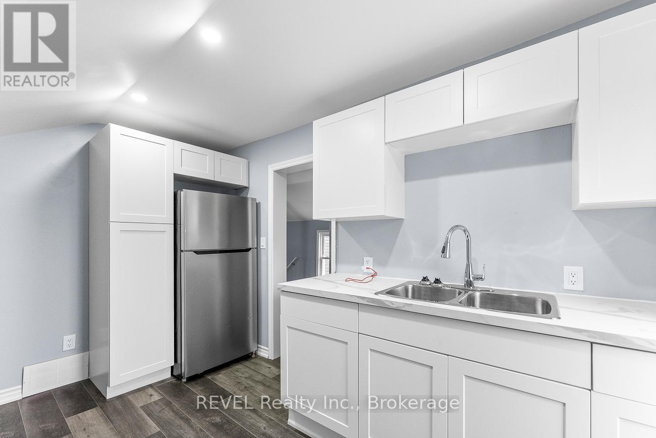 A modern kitchen with white cabinets and stainless steel appliances.