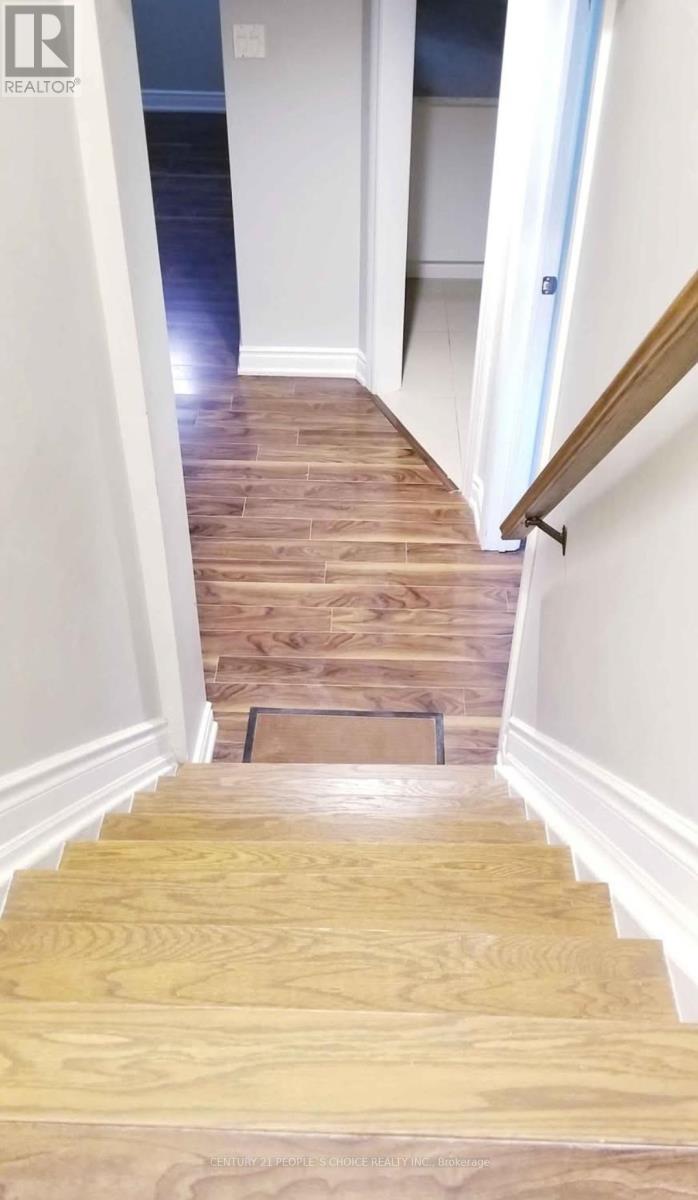 A wooden staircase with a white wall on the side.