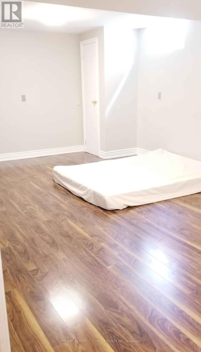 A bedroom with a bed and wooden flooring.