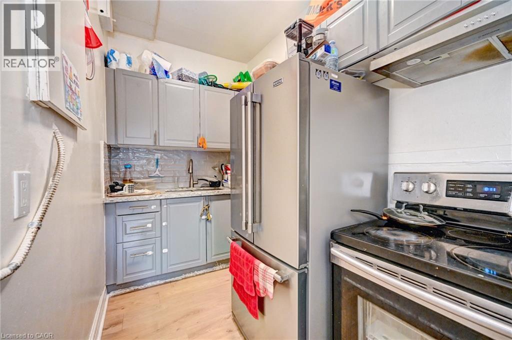 A kitchen with a stove top oven and a refrigerator.