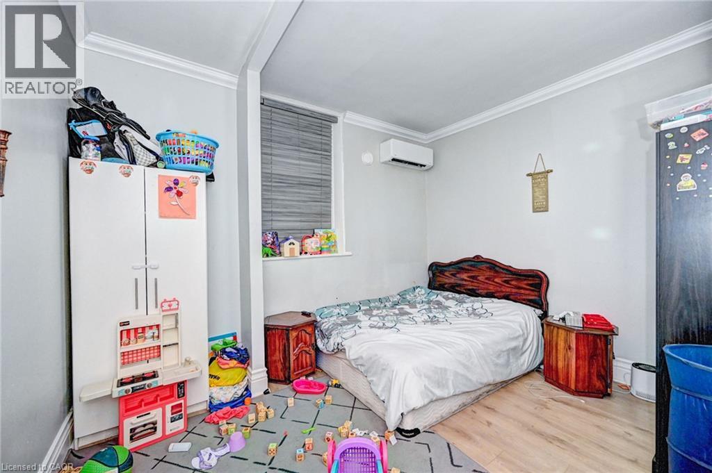A bedroom with a bed, a dresser, and toys scattered on the floor.