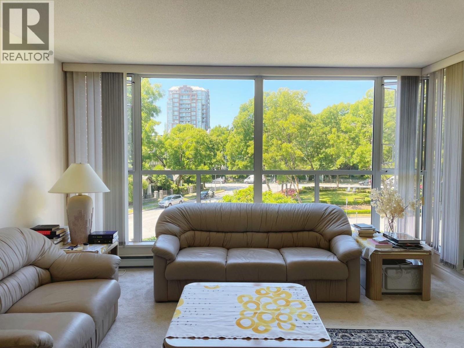 A living room with a large window overlooking a green area.
