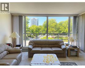 A living room with a large window overlooking a green area.