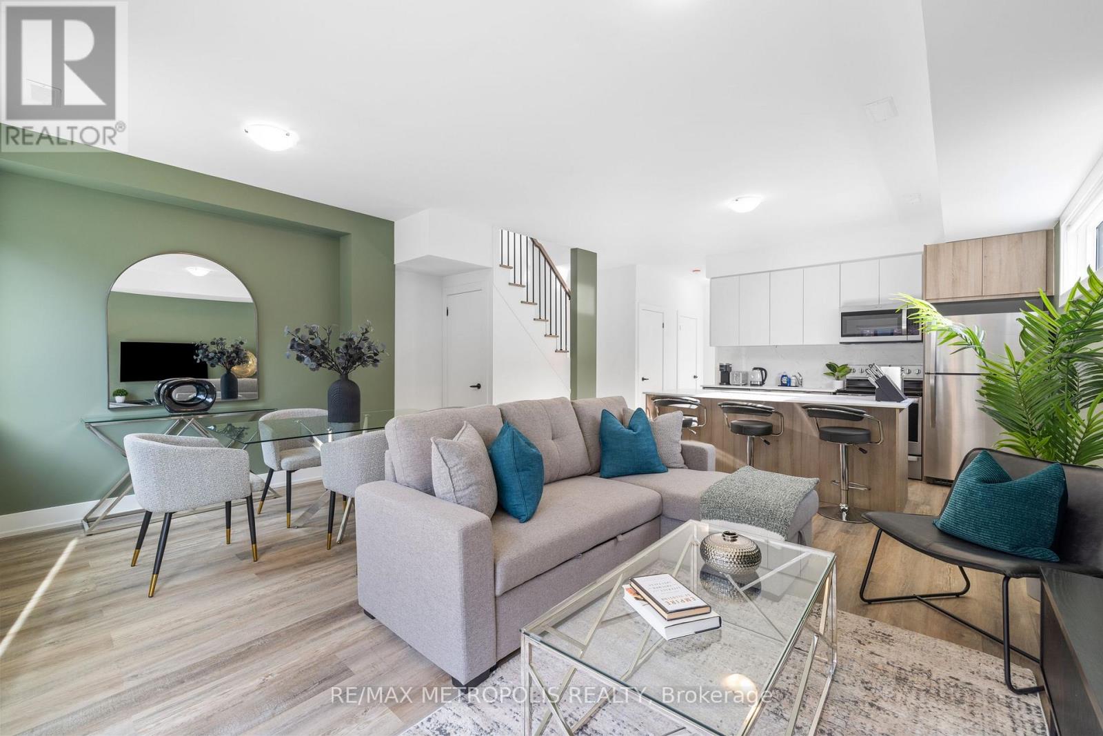 A modern living room with a glass coffee table and a grey sofa.